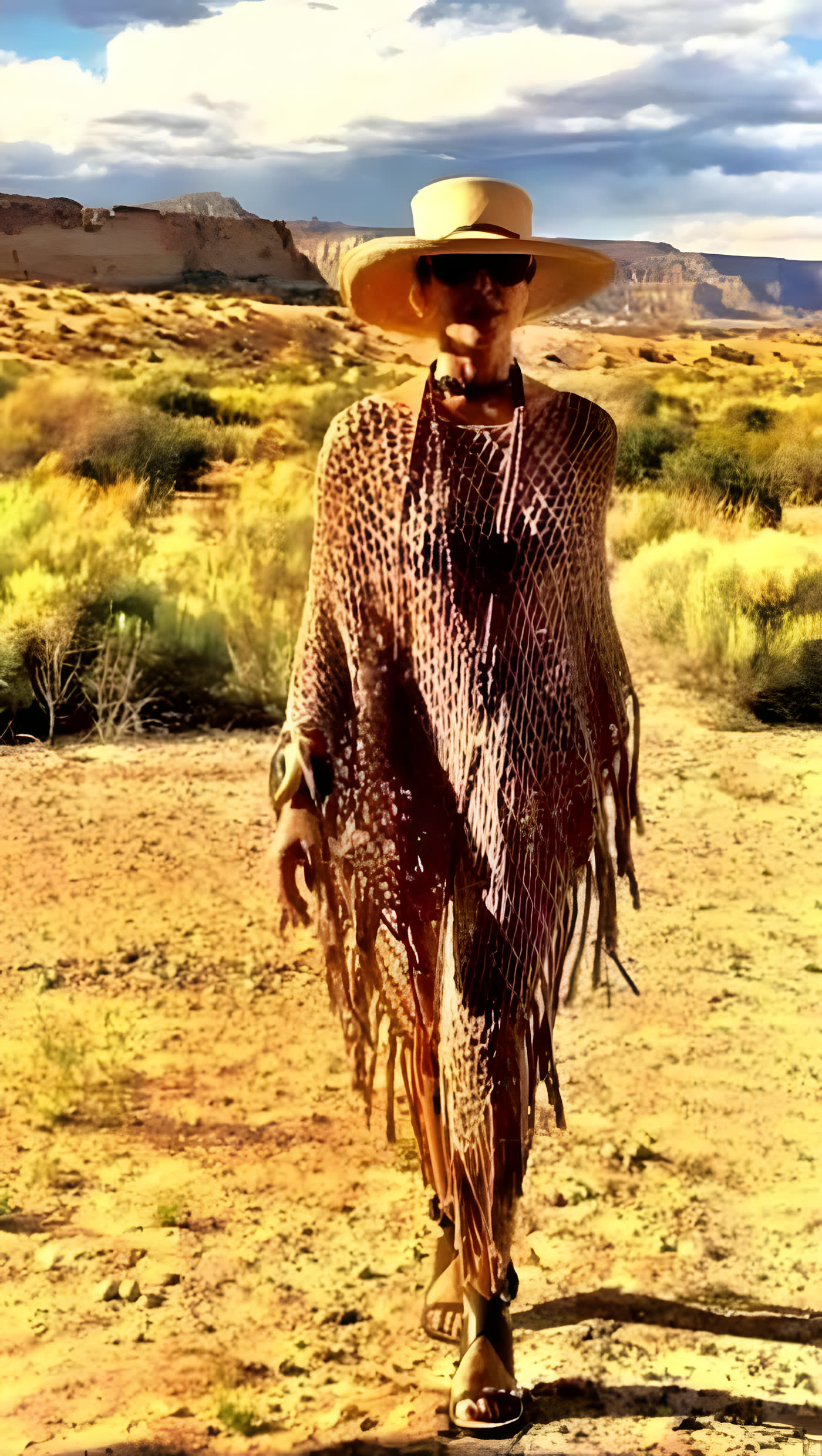 Poncho de red en cacao, con sombrero de ala ancha, en el desierto